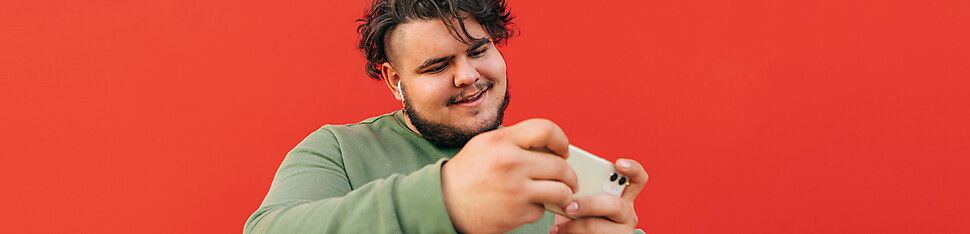 Retrato de homem a rir, com dedo indicador levantado perante computador portátil